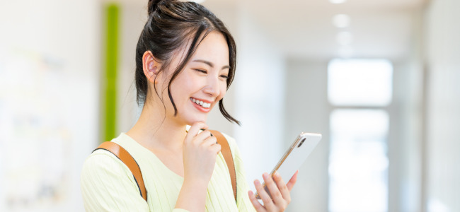 笑顔でスマホを眺める女性